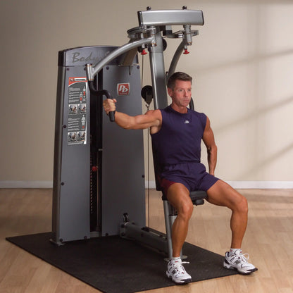 A person demonstrating the Body-Solid Pro Dual Pec & Rear Delt Machine DPECSF, performing a rear delt exercise while seated.