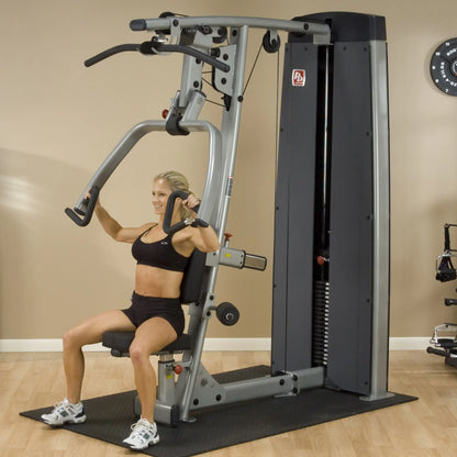 A woman using the Body-Solid Pro Dual Vertical Press & Lat Machine DPLSSF for strength training, demonstrating proper form while seated.