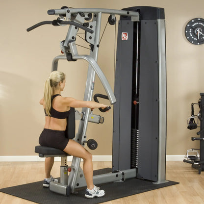 A woman using the Body-Solid Pro Dual Vertical Press & Lat Machine DPLSSF in a gym setting, demonstrating strength training exercises.