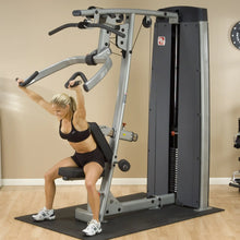 A woman performing an exercise on the Body-Solid Pro Dual Vertical Press & Lat Machine DPLSSF, showcasing strength training in a modern gym setting.