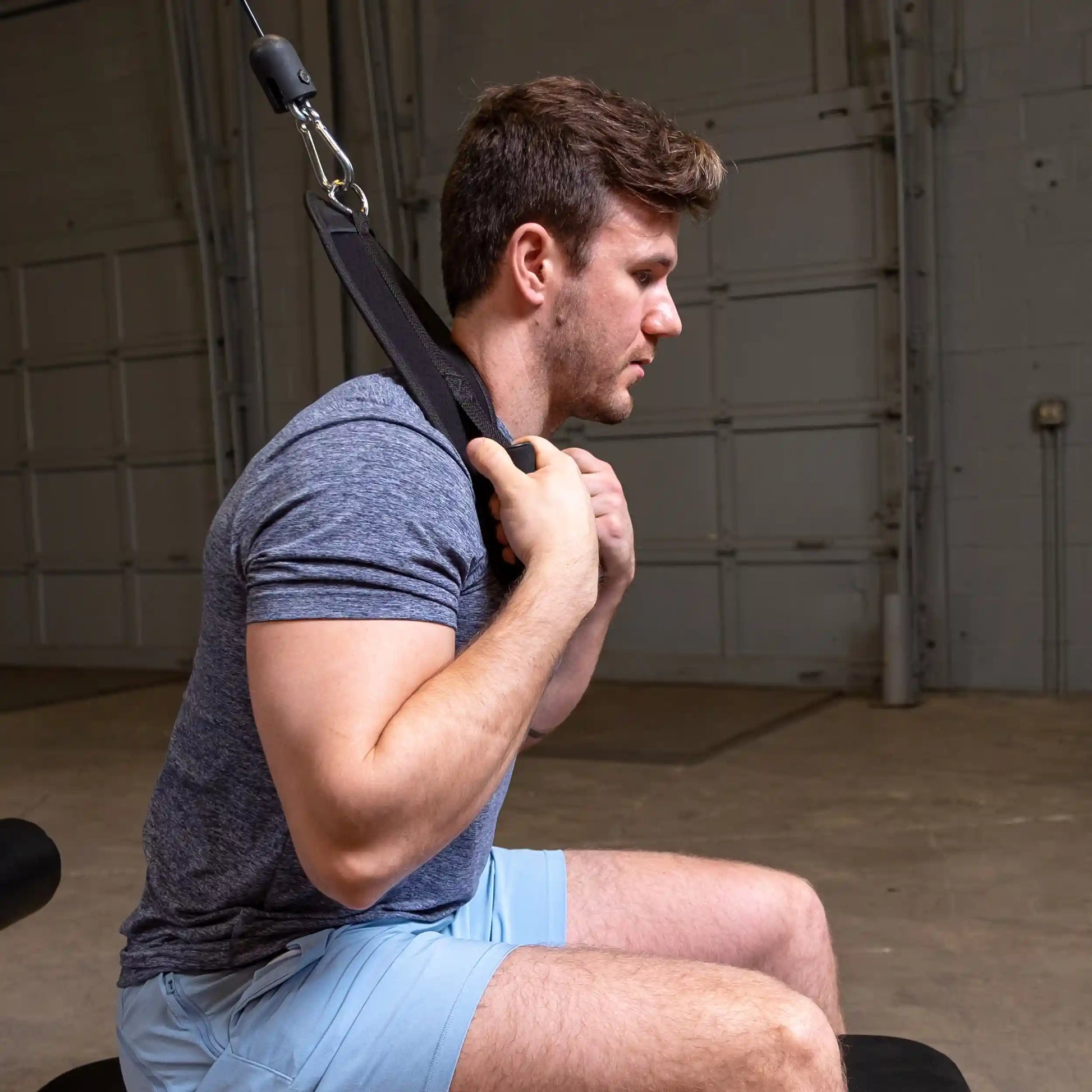 Man using neck harness for strength training in a gym.