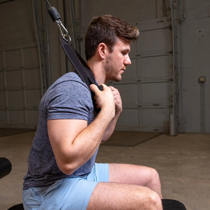 Man using neck harness for strength training in a gym.