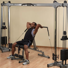 Man using Body-Solid home gym for tricep exercises, wearing black and gray workout attire.