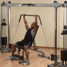 Man using Body-Solid cable machine for strength training in a gym.