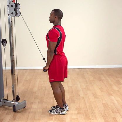 Man in red sportswear performing tricep cable pushdown in gym.