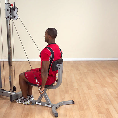 Man in red outfit using a cable row machine for back workout.