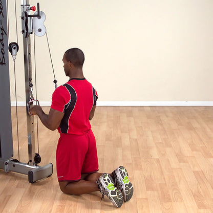 Man in red workout gear performing tricep pushdown on cable machine.