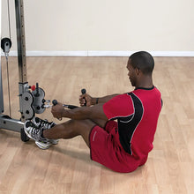 Man in red workout attire using a cable machine for seated rows in a gym.