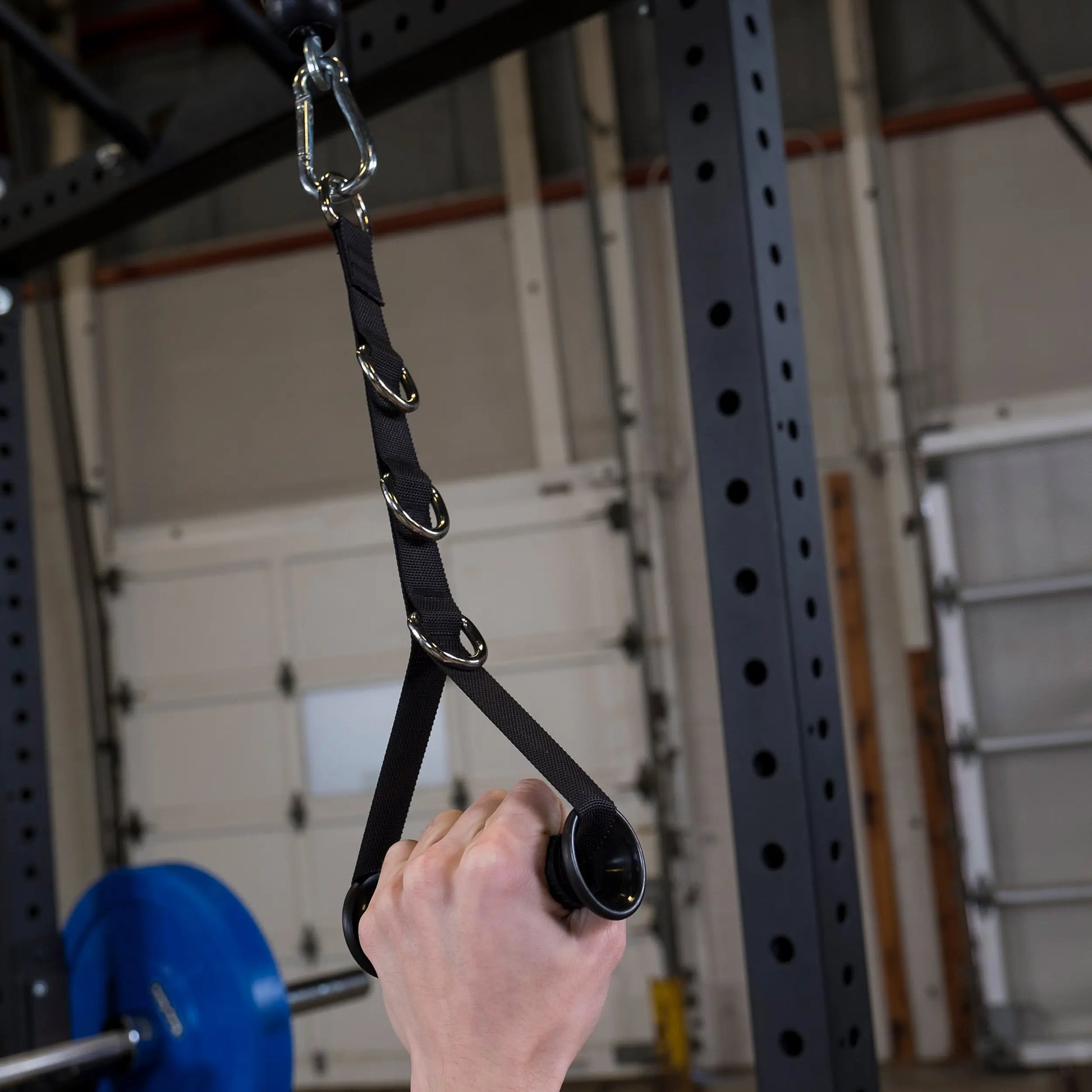 Pull-up assist band with adjustable loops and sturdy grip in a gym setting.