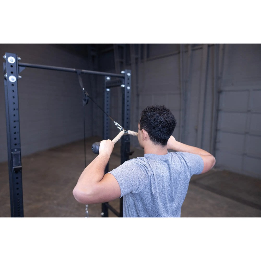 Man using a cable machine for tricep exercises in a gym.