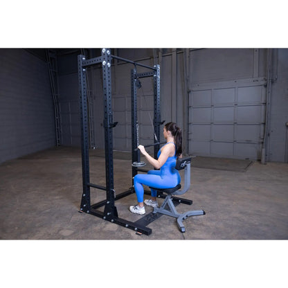 Woman in blue workout gear using a cable machine in a gym.