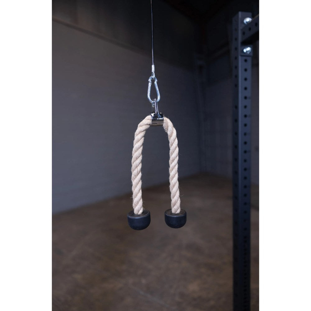 Gym tricep rope attachment with black rubber ends hanging in a fitness center.