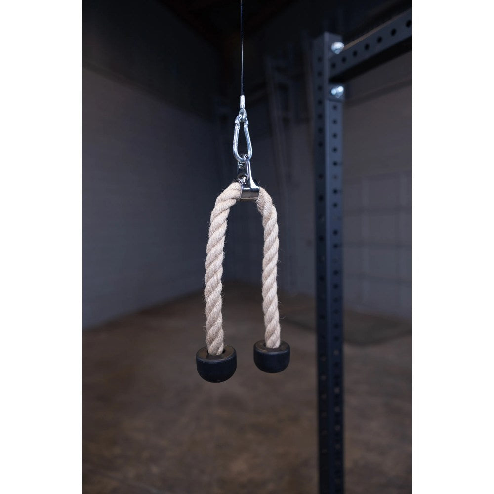 Rogue tricep rope attachment with black rubber ends hanging in a gym setting.