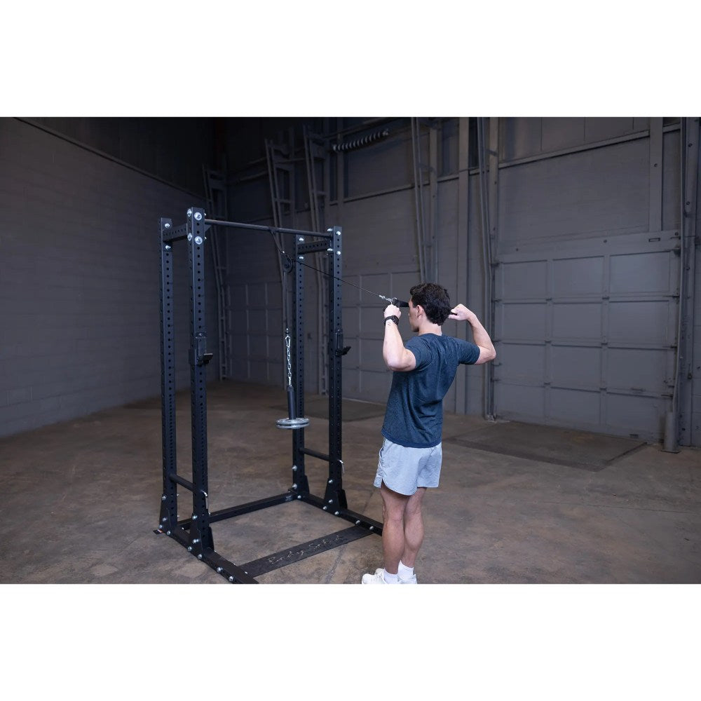 Man using cable machine for tricep workout in a gym.