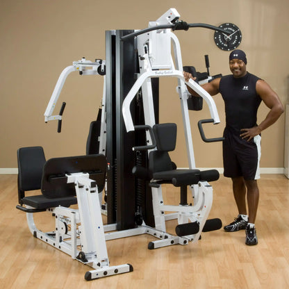 Body-Solid gym equipment with a man in athletic wear standing beside it.