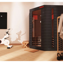 Black infrared sauna in modern home gym with wood accents.