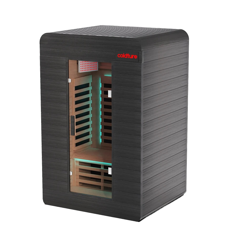 Black infrared sauna in home gym with wooden bench and exercise bike.