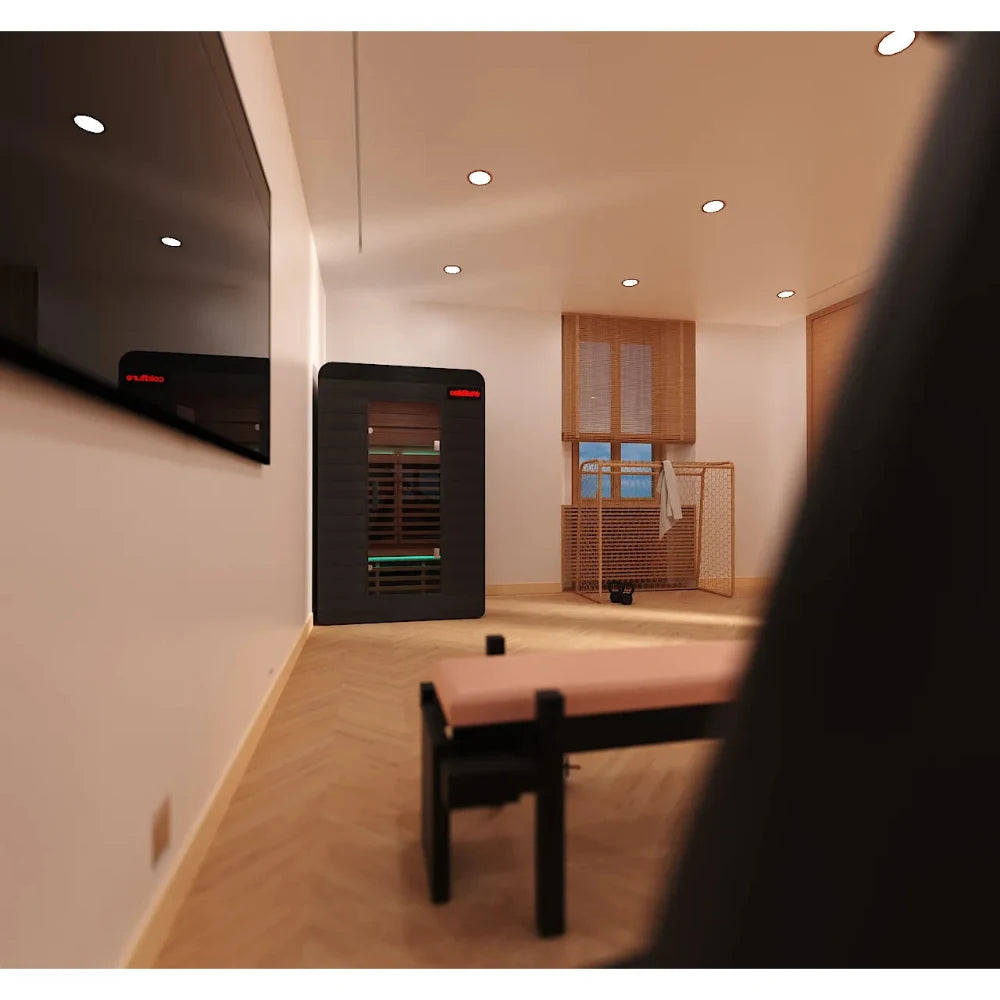 Home gym with a black Sun Home Sauna against a white wall, featuring sleek wooden flooring.