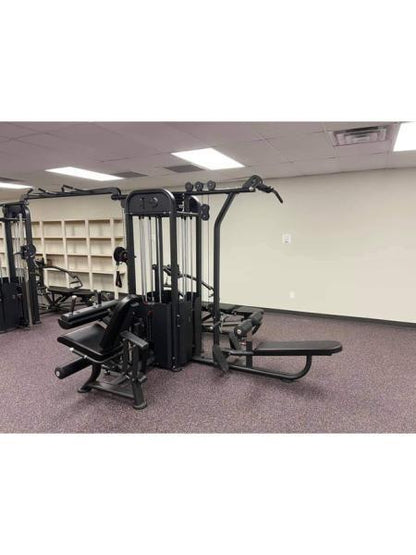 Compact multi-gym with seated row and leg extension in a gym.