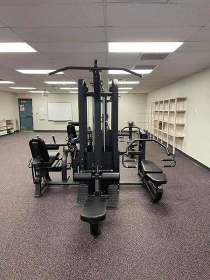 Compact multi-gym with eight-stack weights in a spacious fitness room.