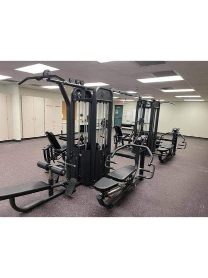 Compact multi-gym exercise station with multiple weight stacks in a gym.