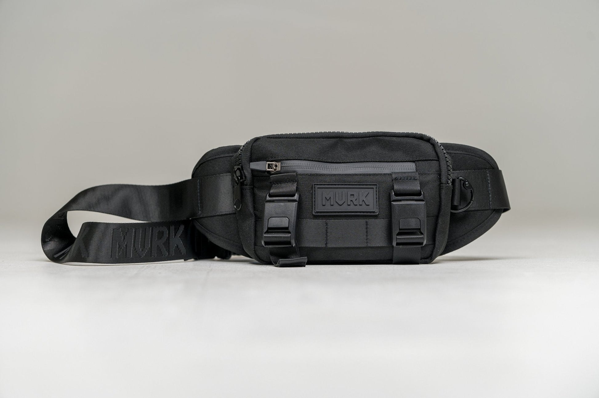Black waist pack with strap and buckles, featuring a MVRK logo on the front.