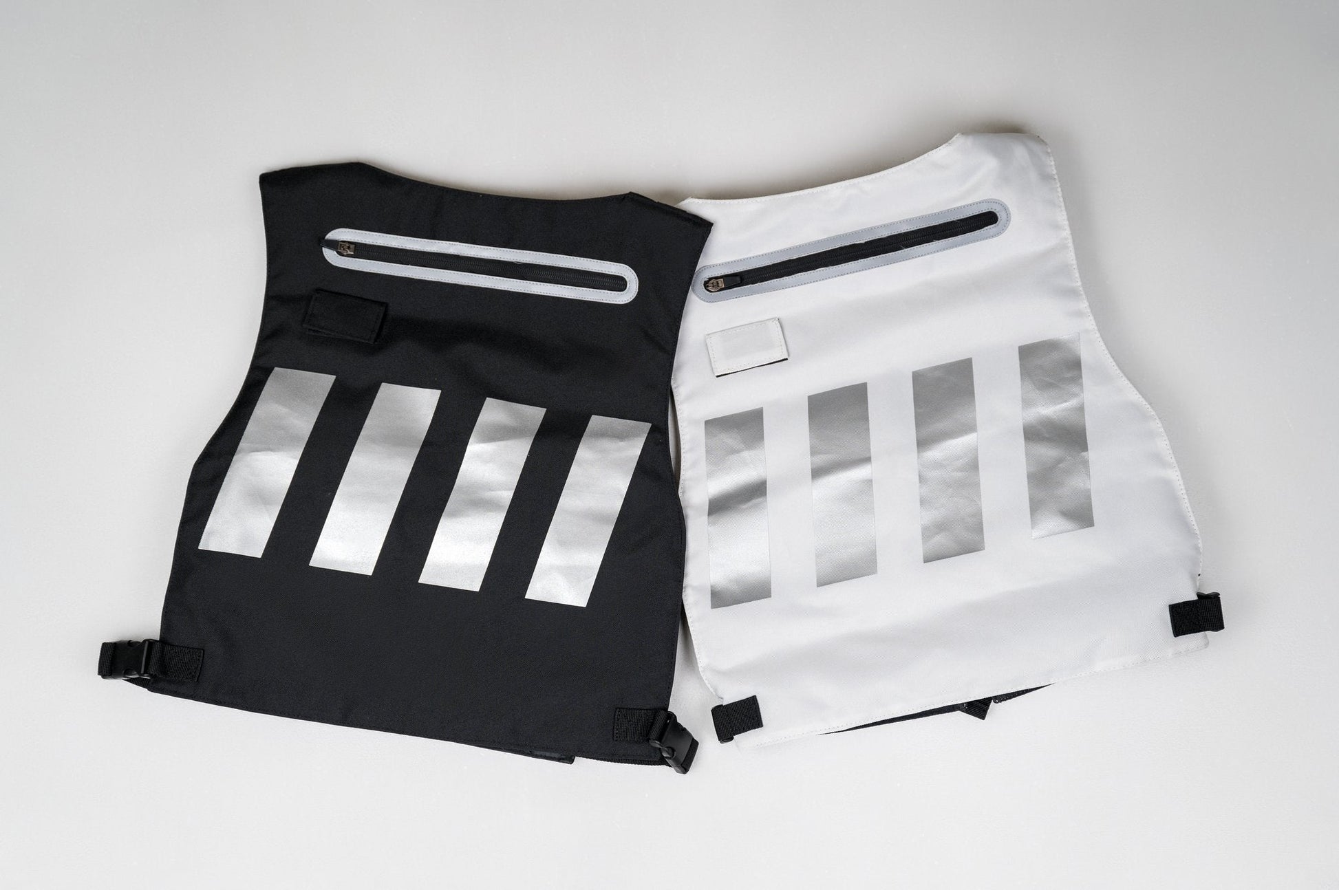 Black and white backpacks with reflective silver stripes and zippers.