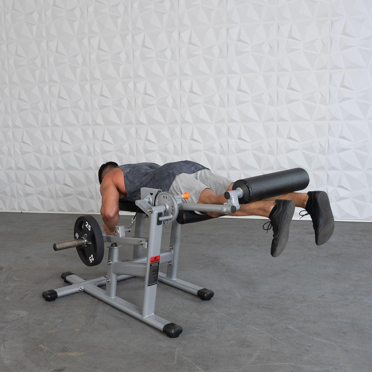 Person performing hip extension on a hyperextension/roman chair with weights.
