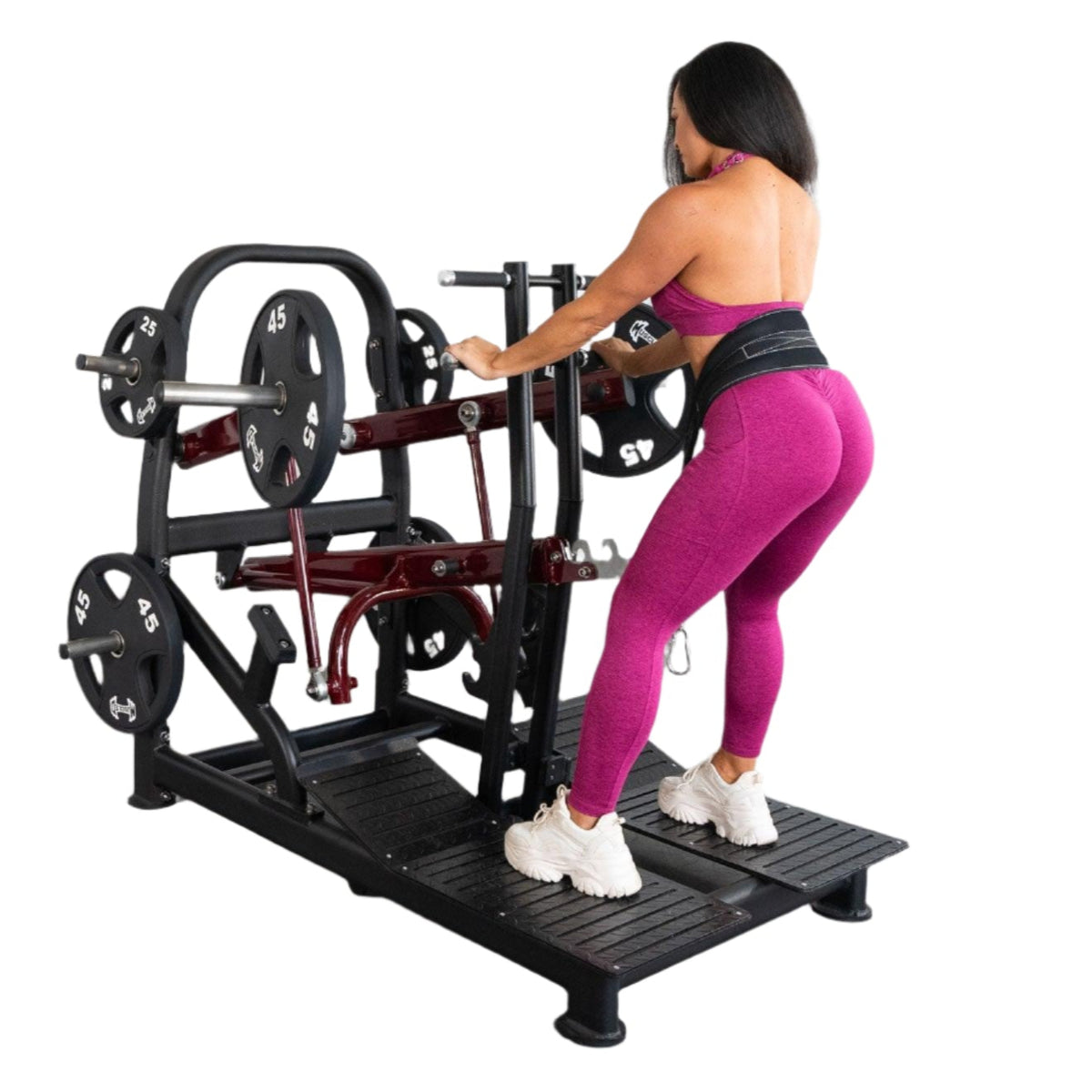 Woman in pink athletic wear using a plate-loaded gym machine.