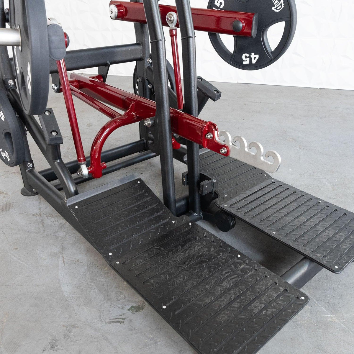 Multi-station gym machine with red frame and black stepping plates.