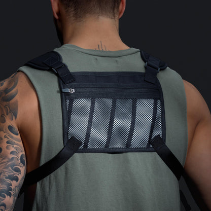 Back view of a man wearing a black tactical vest with a mesh panel.