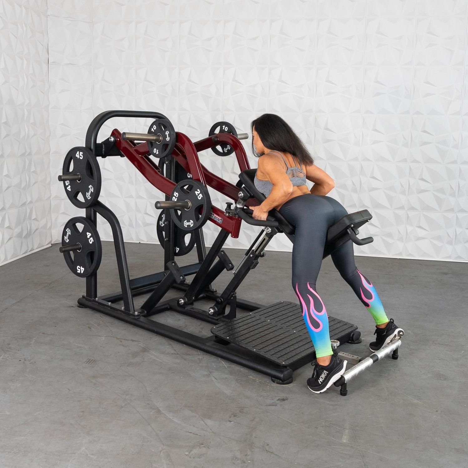 Woman using a Plate loaded row machine with colorful leggings in a gym workout.
