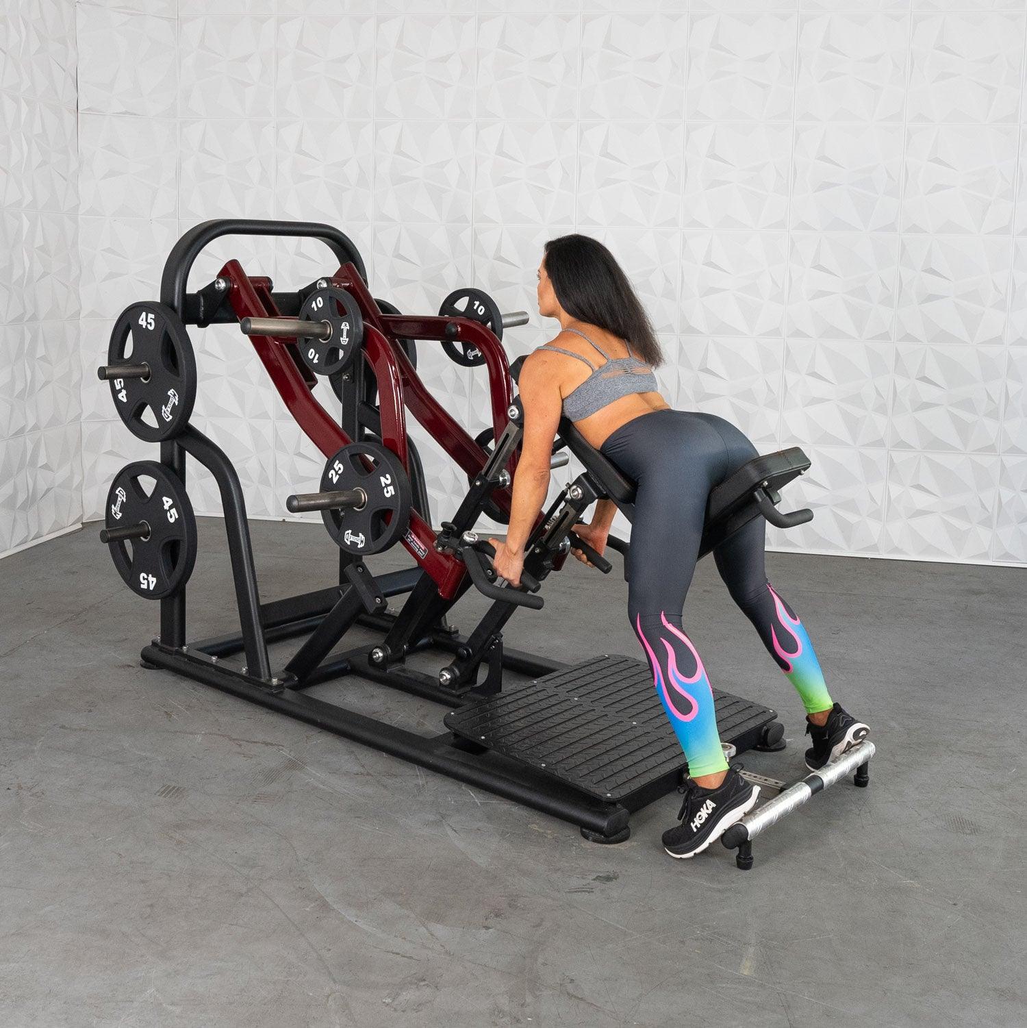 Woman using a Smith machine in colorful leggings for strength training.