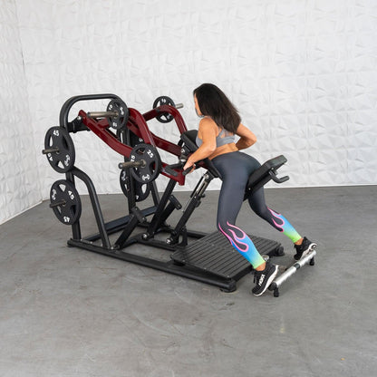 Woman using a black and red plate-loaded row machine for strength training.
