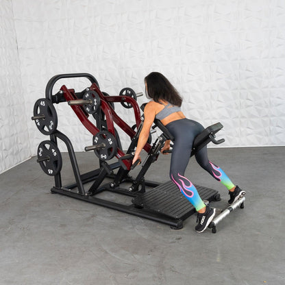 Woman using a seated row machine with weights, wearing colorful leggings.