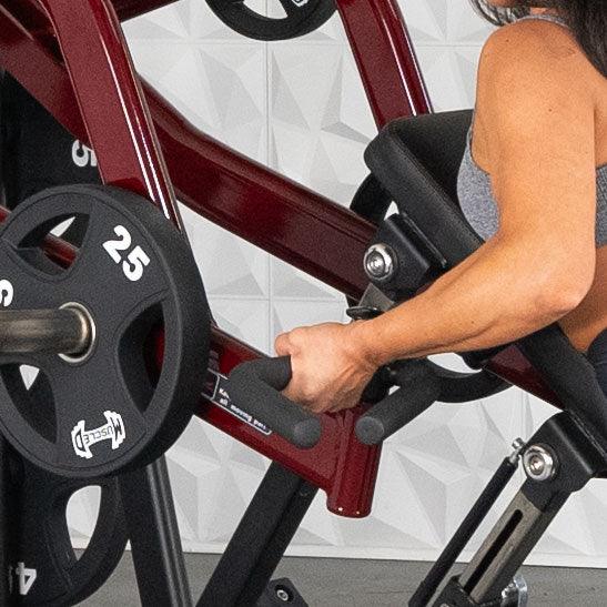 Person using red Muscle D incline row machine with 25-pound weights.