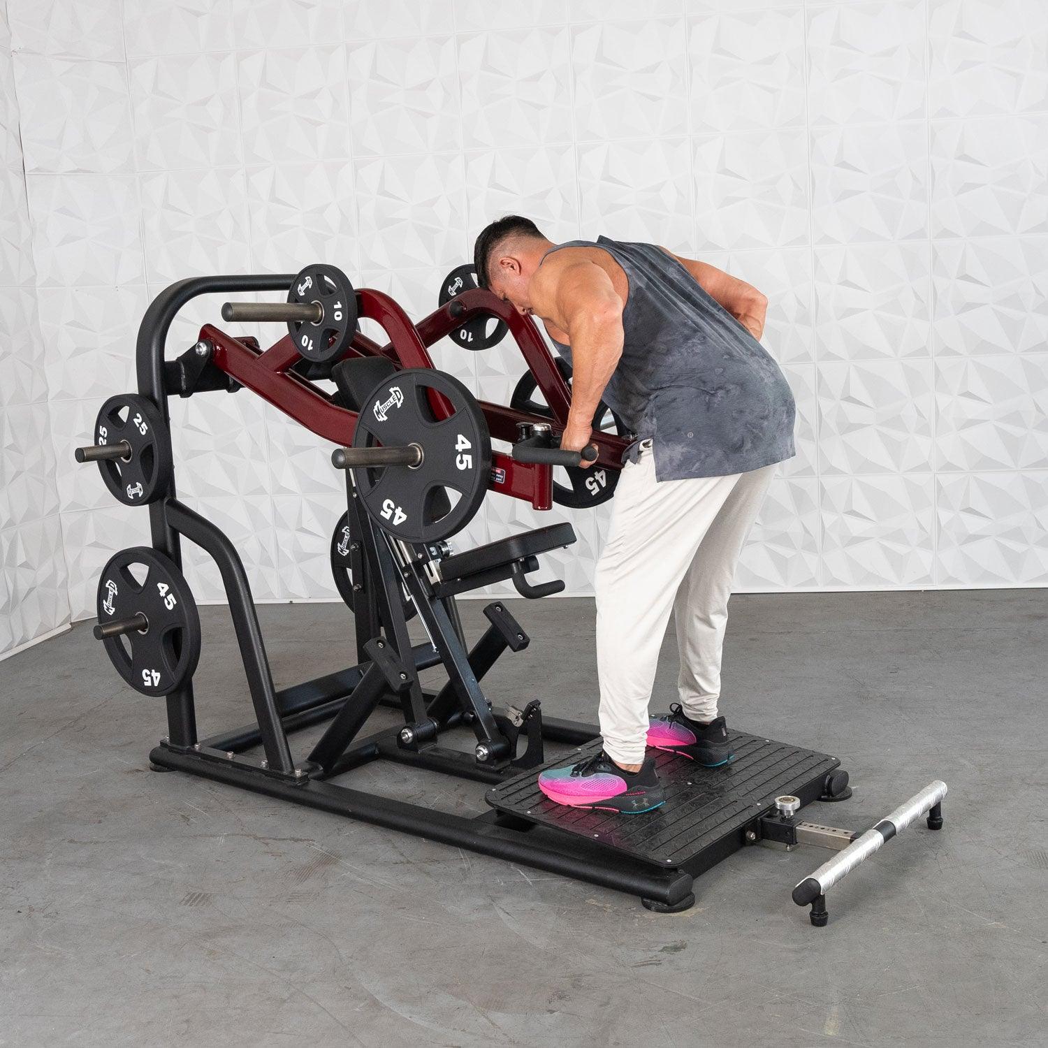 Man using a seated row machine with weights in a gym, wearing pink shoes.