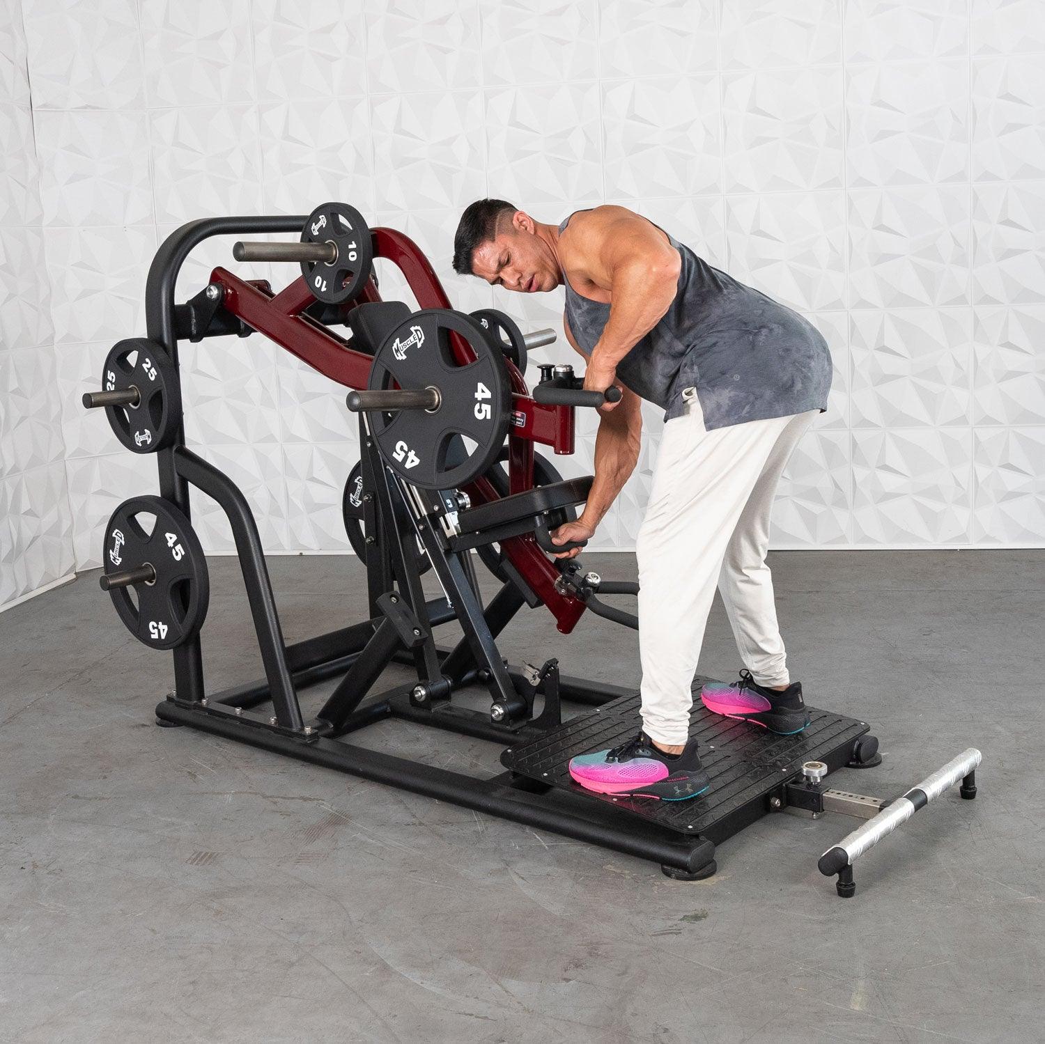 Man using a Plate loaded row machine with red accents for upper body workout.