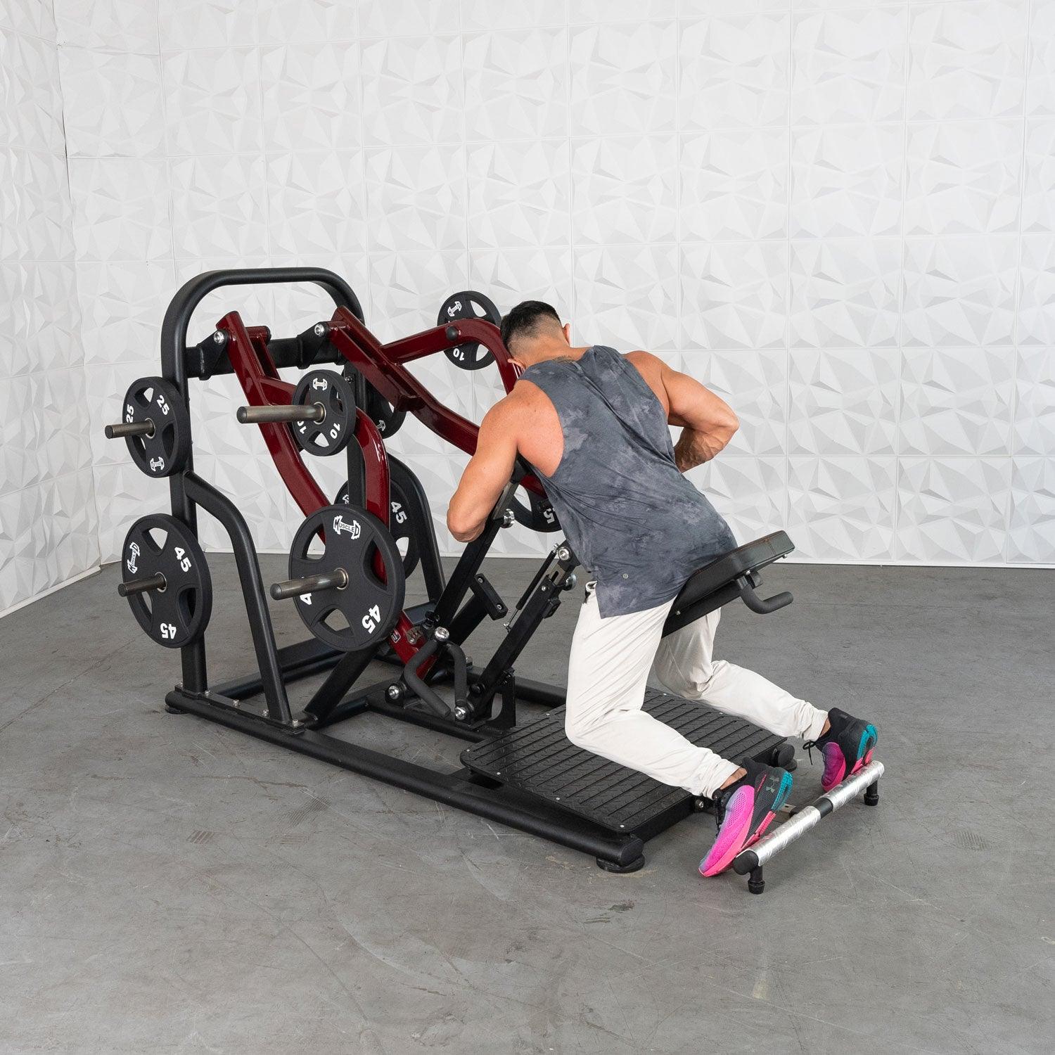Man using a red plate-loaded row machine in workout gear.