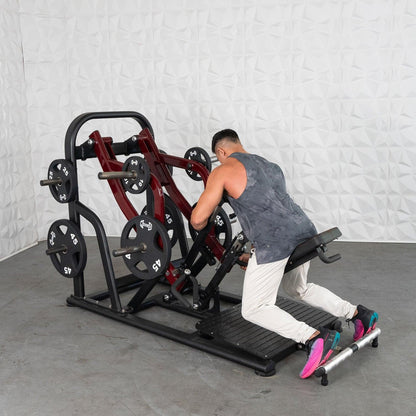 Man using a Plate loaded row machine with multiple weight plates in a gym.