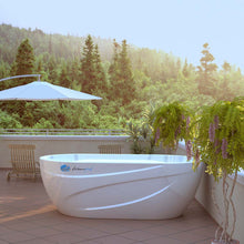 Dreampod Commercial Cold Plunge tub on a patio surrounded by greenery, with a sunshade and potted plants.