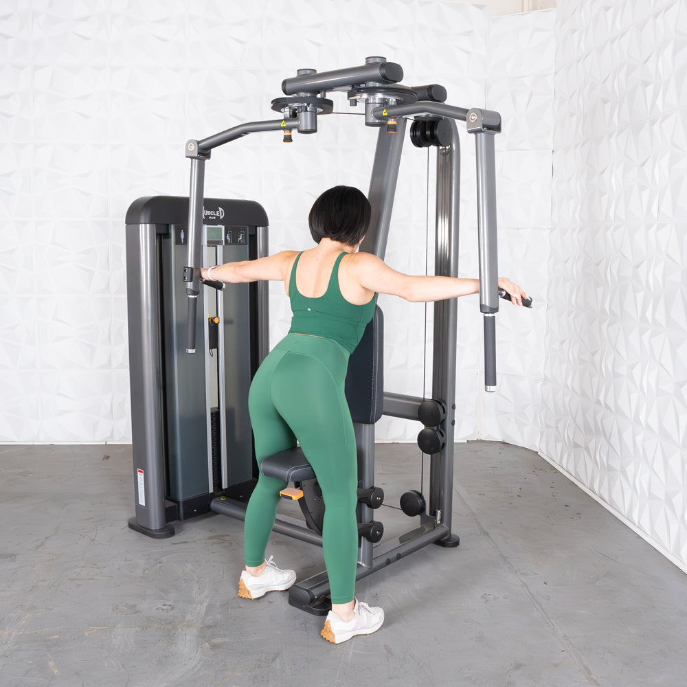 Woman on a gym machine performing rear delt and chest fly exercise.