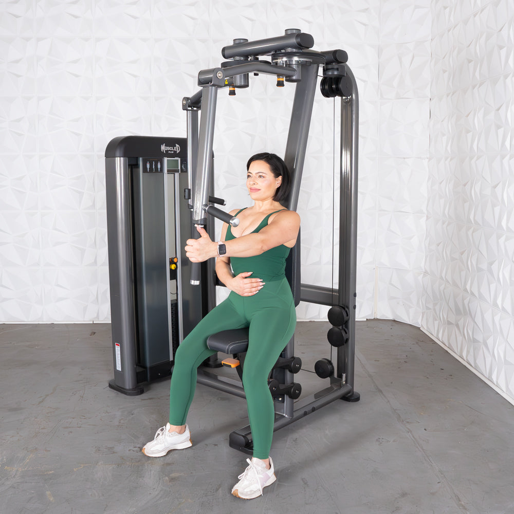 Woman in green athletic wear using a chest/rear-delt gym machine.