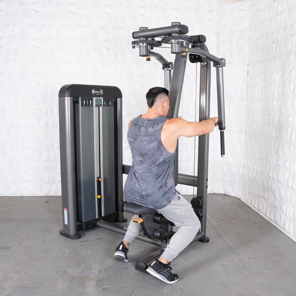 Man seated on a chest and rear delt machine at gym.