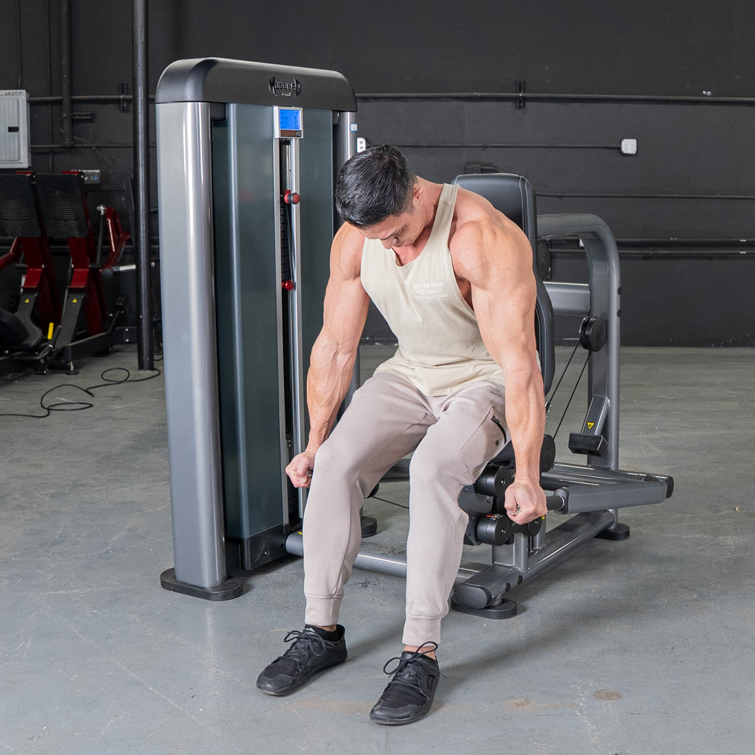 Strong man using a triceps press machine in a gym.