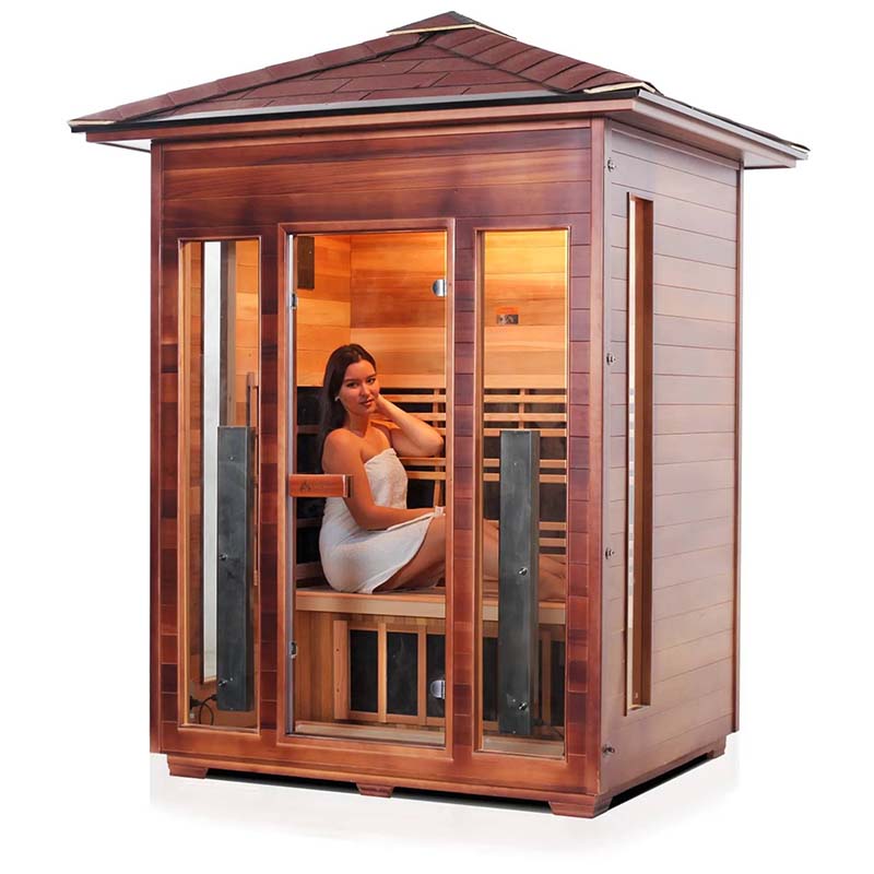 Woman relaxing in a modern cedar wood infrared sauna cabin.
