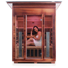 Woman relaxing in a modern wooden infrared sauna cabin.