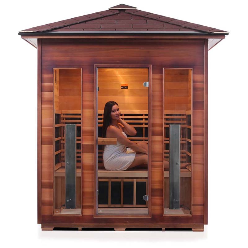 Wooden infrared sauna with a glass door featuring a woman wrapped in a towel.