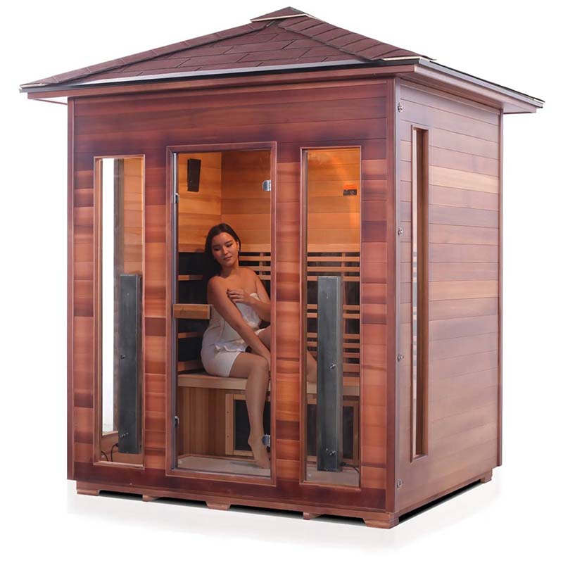 Cedar infrared sauna house with a relaxing woman in a towel inside.