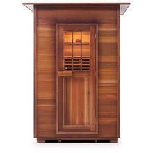 Outdoor cedar sauna with wood panel exterior and glass-paneled door.